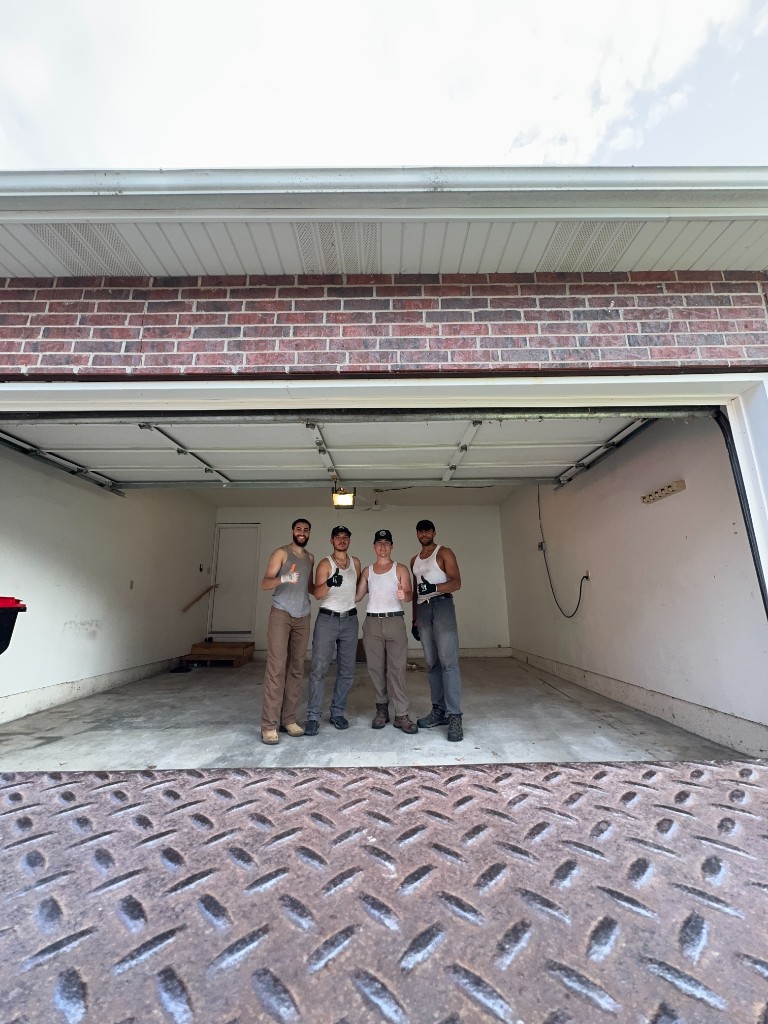 Little Fellas Moving crew standing in a cleared garage after a full cleanout