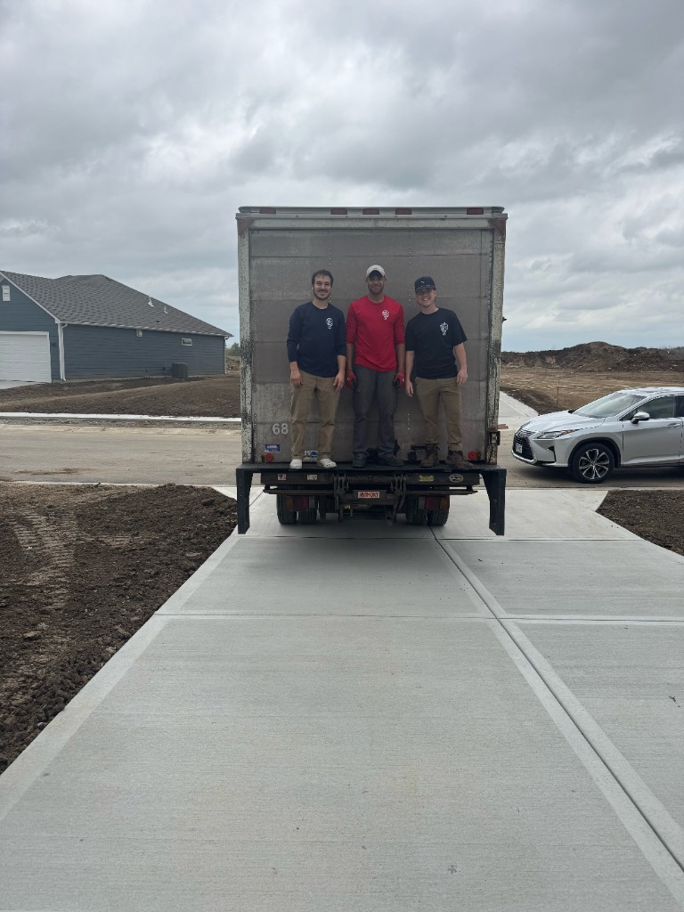 Little Fellas Moving crew with their box truck on a Kansas City driveway, ready to move